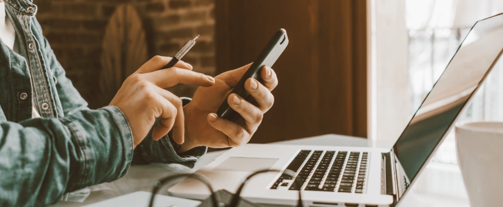a person paying their bills online with their mobile and laptop computer