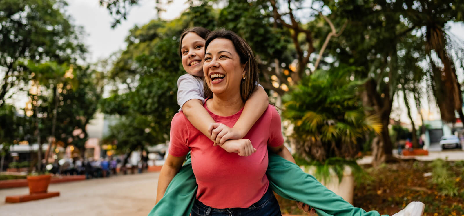 A woman giving a young girl a piggyback ride 
