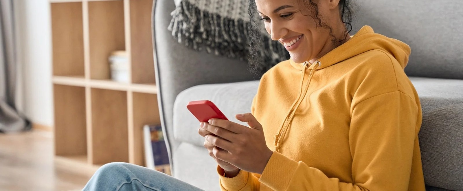 a woman sitting on a floor holding her mobile phone