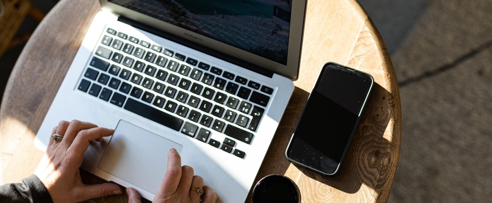 A laptop and a mobile phone on a round desk